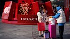 Shoppers stand near a Lunar New Year display in Beijing in February.