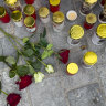Candles and flowers are placed at the site of stabbing a day after an attack that left a 14-year-old dead and five others injured.