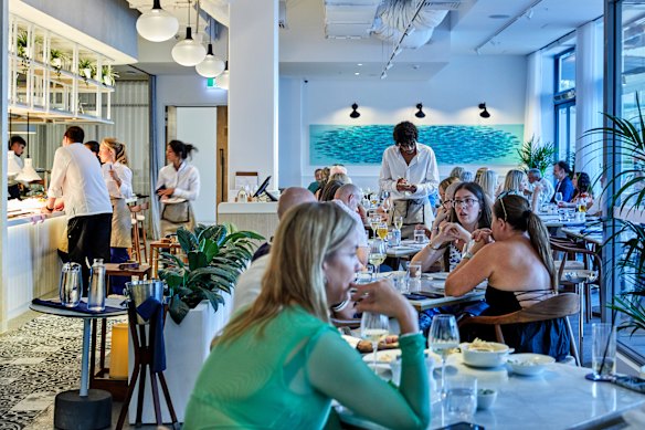 The Kiama-chic dining room is a sea of guests wearing pastels and linen.