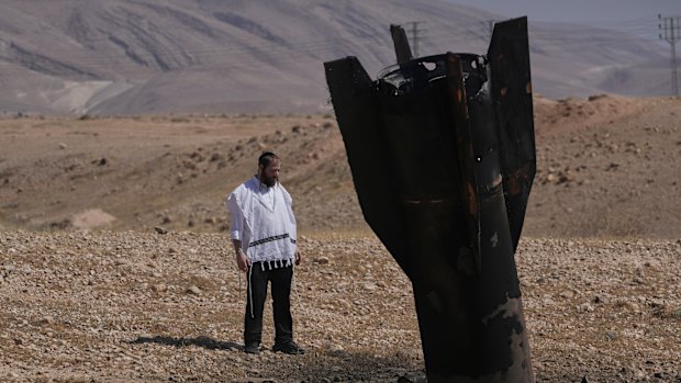 A man looks at the wreckage of an Iranian missile that landed near the West Bank city of Jericho on Monday.