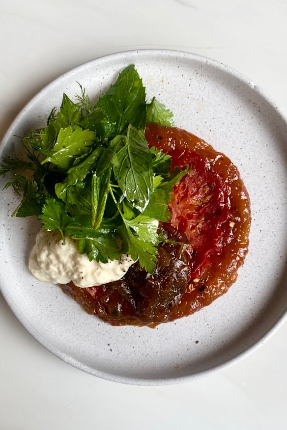 Oxheart tomato tarte tatin with slow onions, stracciatella and fresh herbs.