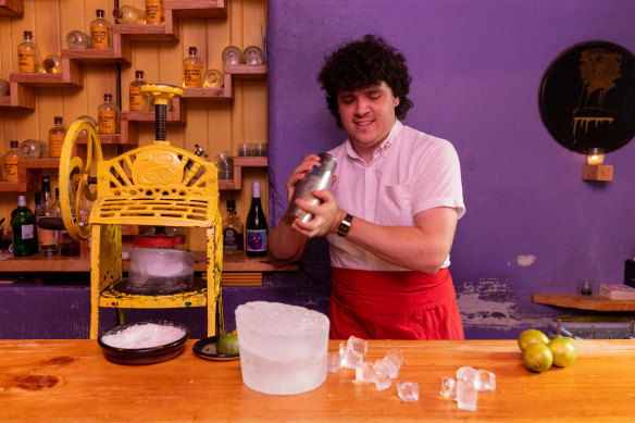 Cantina OK! bartender Storm Evans shaves down giant blocks of ice to make margaritas.