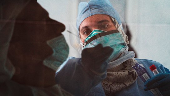 A technician takes a nasal swab for a new coronavirus detection test at a drive-thru testing facility in Abu Dhabi, United Arab Emirates.