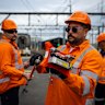 Workers demonstrate a new hand-held laser device used to check over-head wiring on Sydney’s passenger train network.