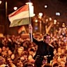 A man waves a Hungarian flag as he celebrates in the streets after the announcement of partial results.