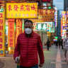 Residents wearing face masks walk on a street in Macau, China. 