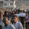 Palestinians collect sacks of flour from an aid distribution point in Beit Lahia, northern Gaza.