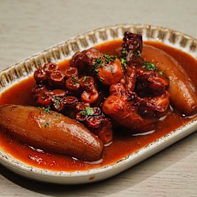 Stifado stew with octopus, shallots, vinegar, cinnamon and star anise in a tomato-tinged gravy. 