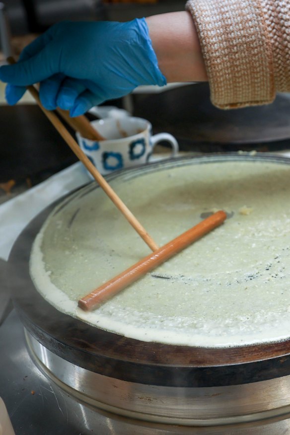 Batter is fanned out over a hotplate at Wow Crepes.