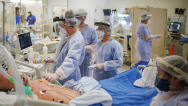 Health workers tend to a COVID-19 patient in the ICU ward at the Hospital das Clinicas in Porto Alegre, Brazil, on March 19.