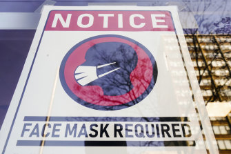 Rule extended: A sign requiring masks as a precaution against the spread of coronavirus is posted on a storefront in Philadelphia.