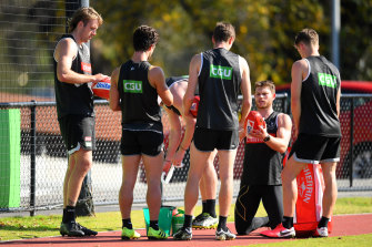 Taylor Adams wipes down the footballs during Collingwood's training session at the Holden Centre.