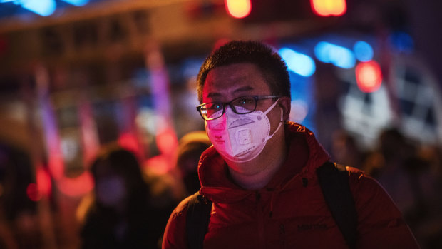 A Chinese man wears a protective mask as he arrives to board a train at Beijing railway station ahead of the Lunar New Year.