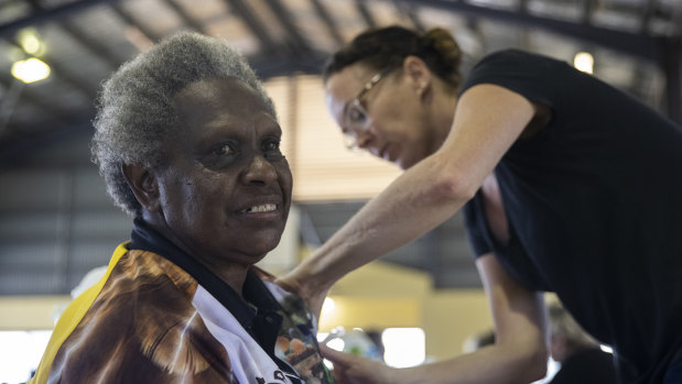 Rosie Gibuma receives a vaccination at the Boigu community centre from Queensland Health nurse Ruth Ferguson.