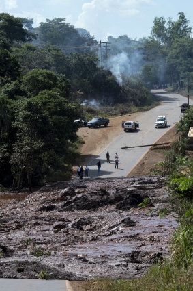 A road is blocked due to the collapsed dam, which has left 200 people missing.