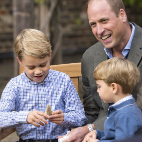 Prince William and Prince Louis react as Prince George holds the tooth of a giant shark given to him by Naturalist Sir David Attenborough.