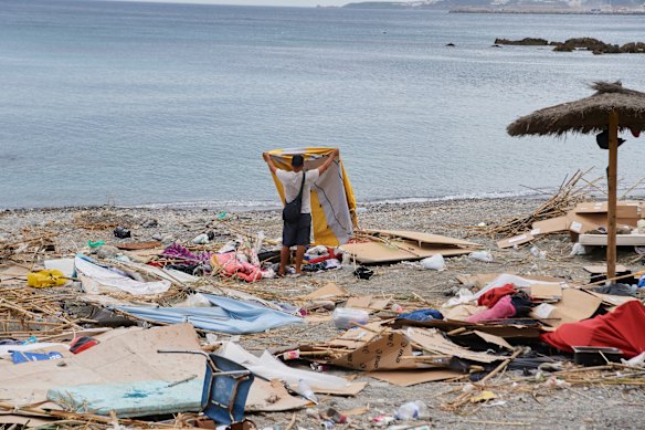 A migrant who crossed from Morocco into Spain gathers his belongings after being cleared from the beach last month.