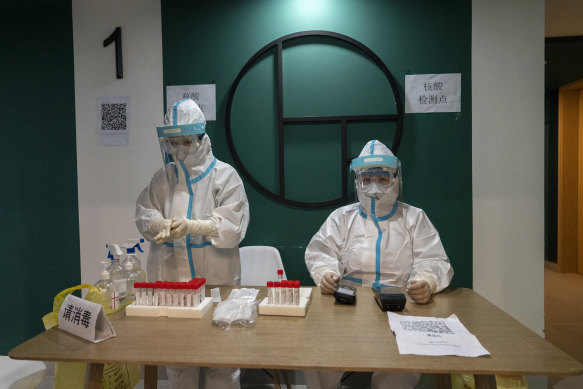 Medical workers prepare to test media for COVID-19 at a test event in December last year.