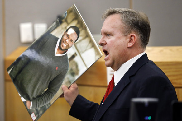 Assistant District Attorney Jason Hermus waves a photo of Botham Jean at the jury during the trial.