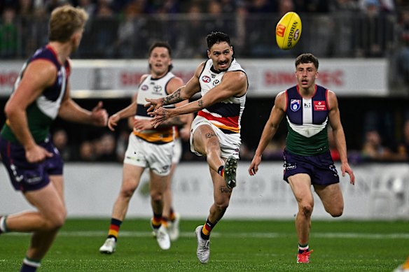 Izak Rankine of the Crows kicks the ball.