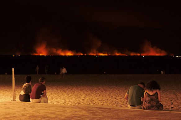 



Da una spiaggia di Arcachon, abitanti e vacanzieri osservano stupiti l'incendio che infuria sull'altro lato della baia, a Lège-Cap-Ferret. 