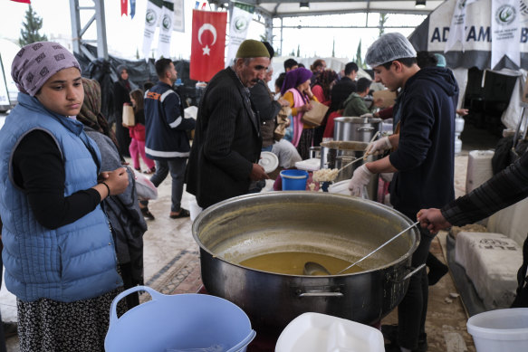 Earthquake survivors take food from a volunteer group to break their fast in Adiyaman, Turkey.