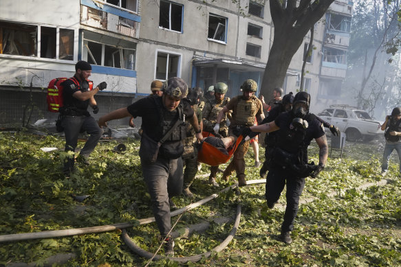 Rescuers carry a body of a resident killed in the Russia’s guided air bomb strike in Kharkiv, Ukraine, on Friday.