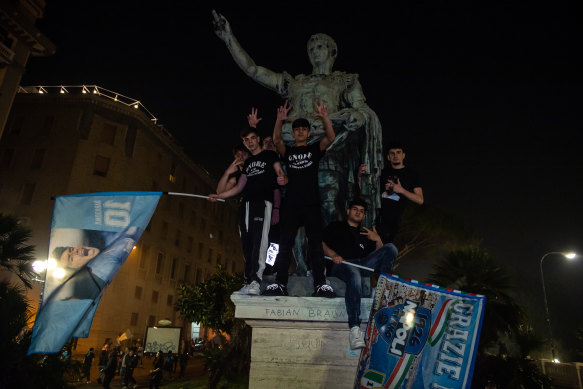 Fans gather near a statue of Maradona.
