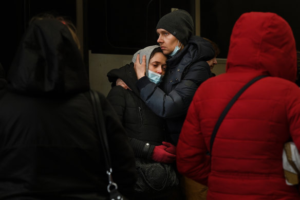 A young couple embrace on the platform at Lviv railway station.