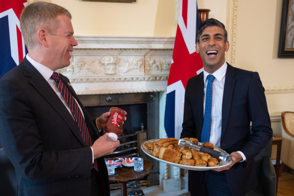 British Prime Minister Rishi Sunak, right, presents New Zealand’s Prime Minister Chris Hipkins with a plate of sausage rolls.