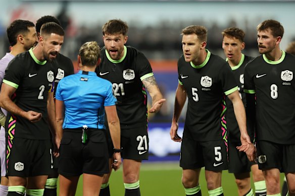 Socceroos players speak with referee Tori Penso after her decision to give Colombia a penalty.