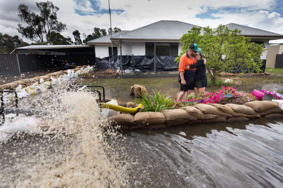 Kim Hay and son Trent Wilson put up a new wall of sandbags after an earlier breach.