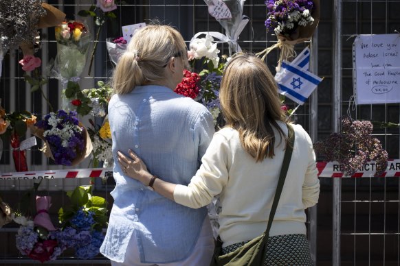 People lay flowers at the synagogue in Ripponlea on Sunday.
