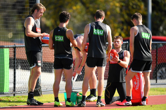 Taylor Adams wipes down the footballs during Collingwood's training session at the Holden Centre.
