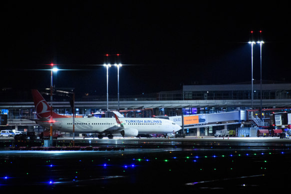 An aeroplane from carrier Turkish Airlines is grounded and surrounded by police vehicles.