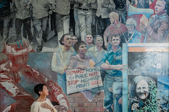 Judy Mundey at a mural that shows her late husban, Jack Mundey, with a loudhailer addressing members of the Builders Labourers Federation and green ban supporters.