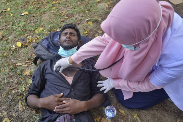 An ethnic Rohingya man receives medical treatment from a health worker after he and his group landed in Indonesia.