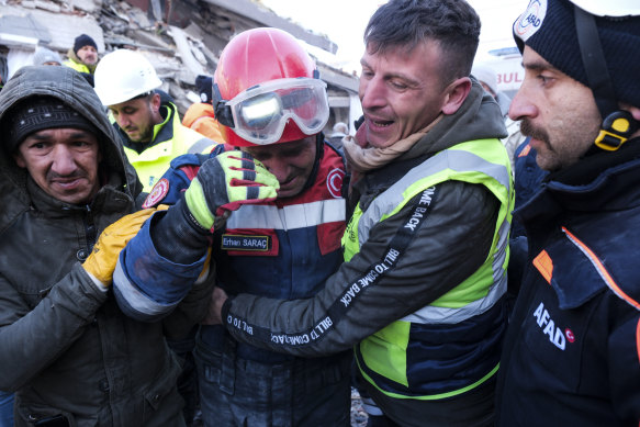 Fireman Erhan Sarac and other rescue team members celebrate a successful rescue in Elbistan, Turkey, on Thursday.