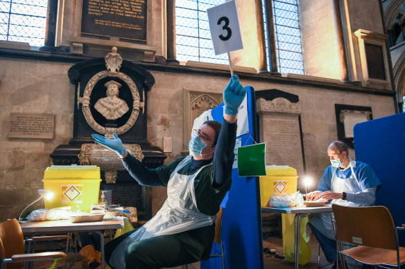 A vaccinator calls for the next patient inside the cathedral’s transept.