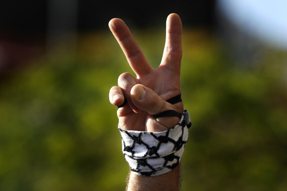 A protester flashes a victory sign  during a protest in support of Palestinians in the latest round of violence between Palestinians and Israelis, in Beirut, Lebanon.