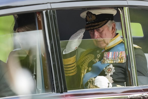 King Charles III salutes as he leaves Westminster Abbey.