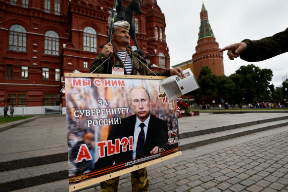 A man holds a placard in support of Russian President Vladimir Putin.