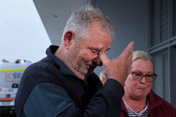 Paul Brennan (left) becomes emotional after being rescued from their Oxley Island home.