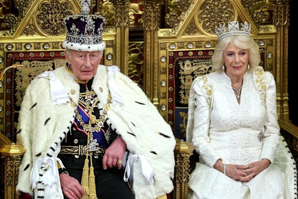 King Charles III and Queen Camilla smile during the King's Speech in the House of Lords on Wednesday.