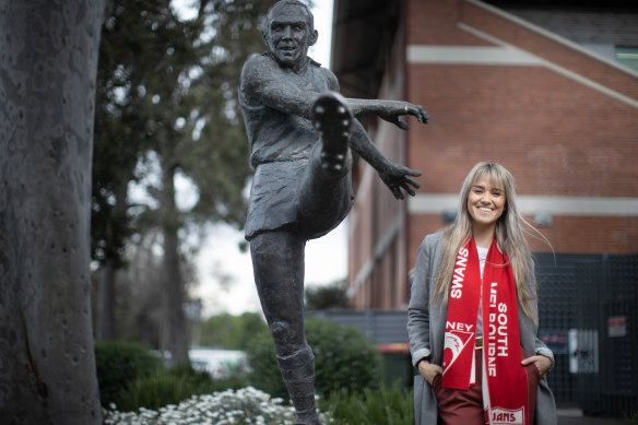 Bec Skilton stands next to a sculpture of grandfather Bob at Melbourne’s Lakeside Stadium, where he played almost half of his 237-game career.