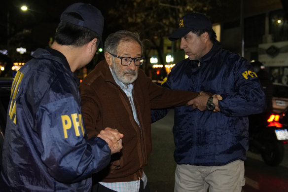 Police escort Juan Percowicz to serve pre-trial detention at his home in Buenos Aires.