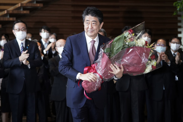 Shinzo Abe receives a bouquet of flowers before leaving the prime minister's office  on Wednesday.