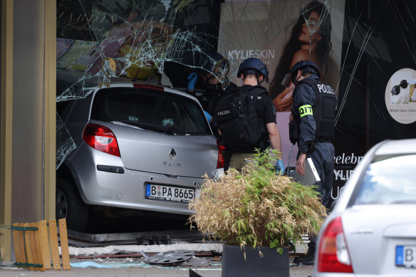 Police investigators stand near a car that ploughed into pedestrians in Berlin.