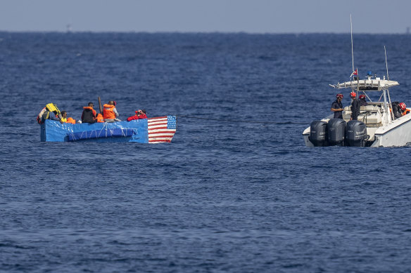 People in a makeshift boat with the US flag painted on the side are captured by the Cuban Coast Guard near the Malecon seawall in Havana, Cuba.
