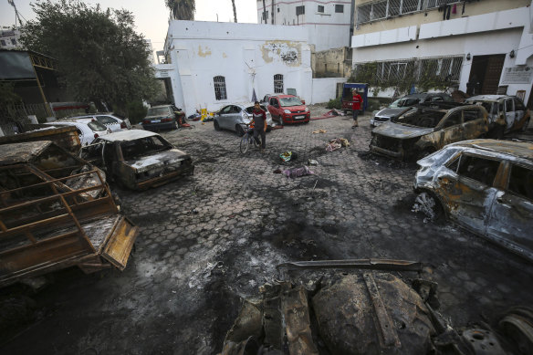 Men look over the site of a deadly explosion at Al Ahli Hospital in Gaza City, 